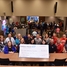 Educators pose for a photo with big check for STEM grants