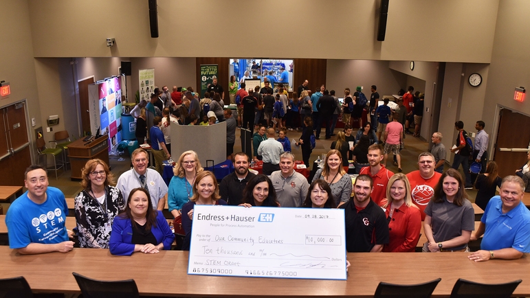 Educators pose for a photo with big check for STEM grants
