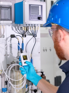 Man checking the conductivity value with CML18 at a measuring point in his production plant