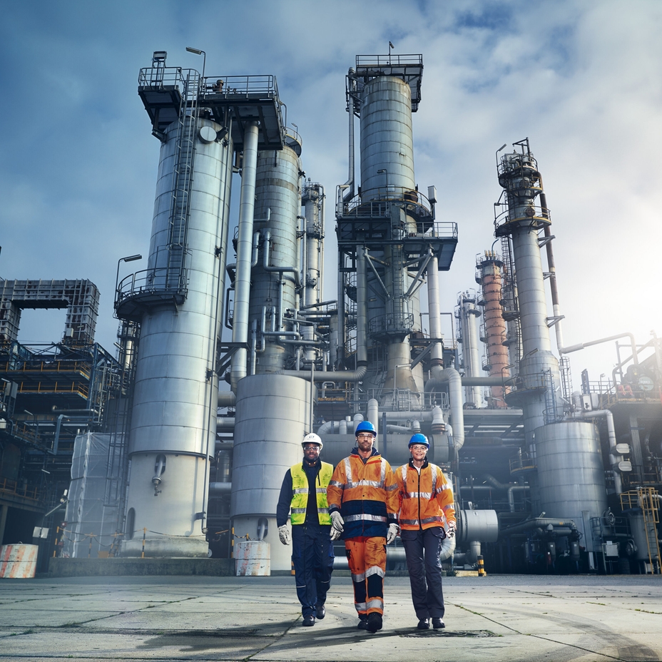Close up picture of an engineer in front of a refinery