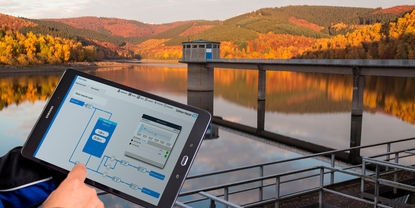Dashboard of Netilion Network Insights in front of a water reservoir
