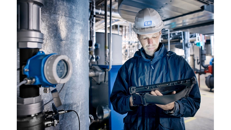 Temperature transmitter iTEMP TMT142B next to an Endress+Hauser employee in the field
